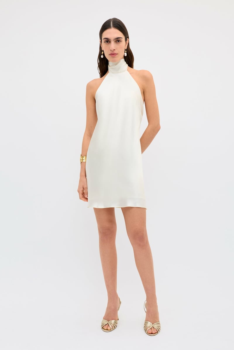 a model wears a white satin halter-neck mini wedding dress
