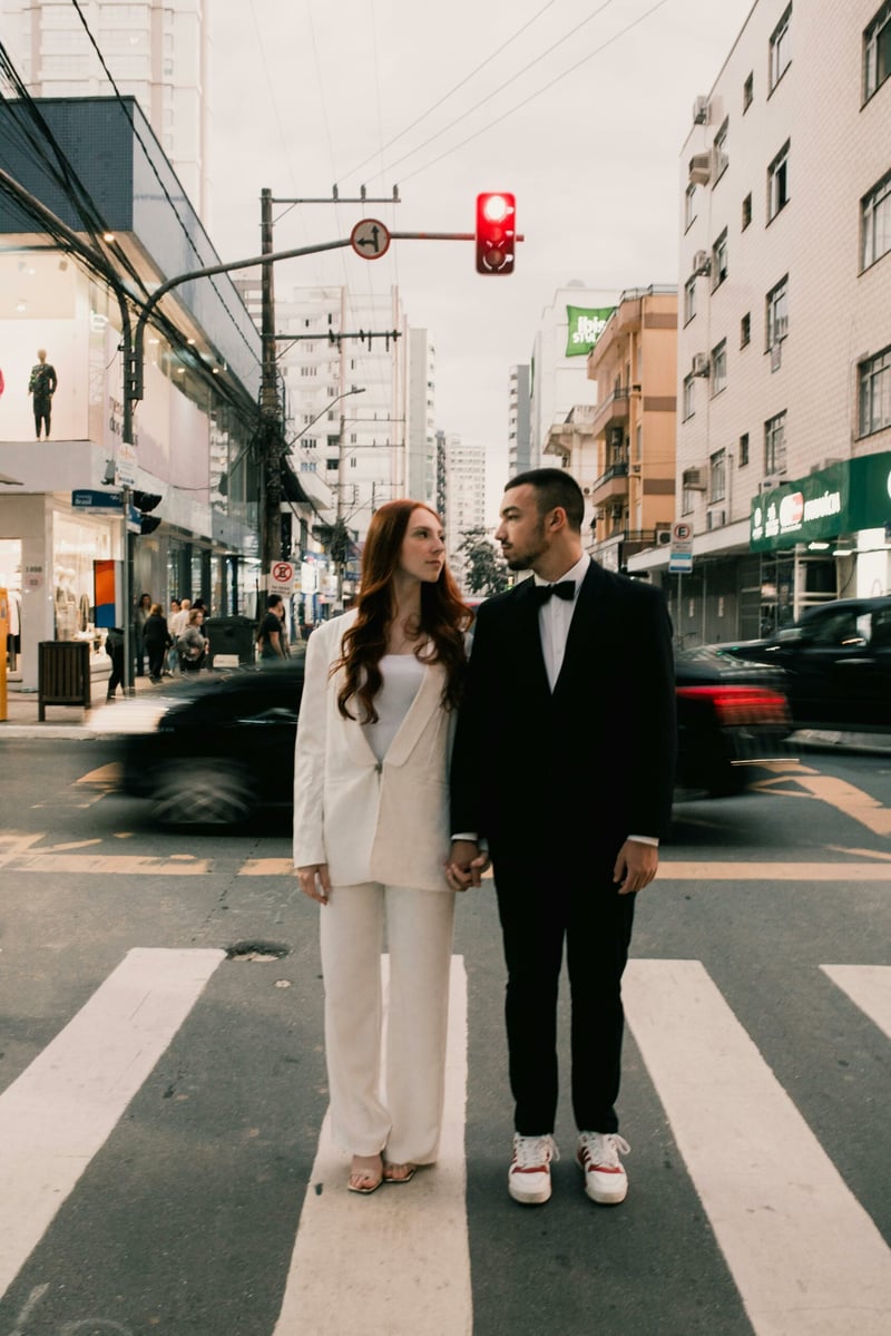 Couple standing hand in hand in a busy street during a city wedding