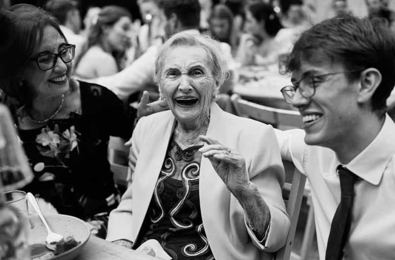 black and white image of wedding family guests together laughing