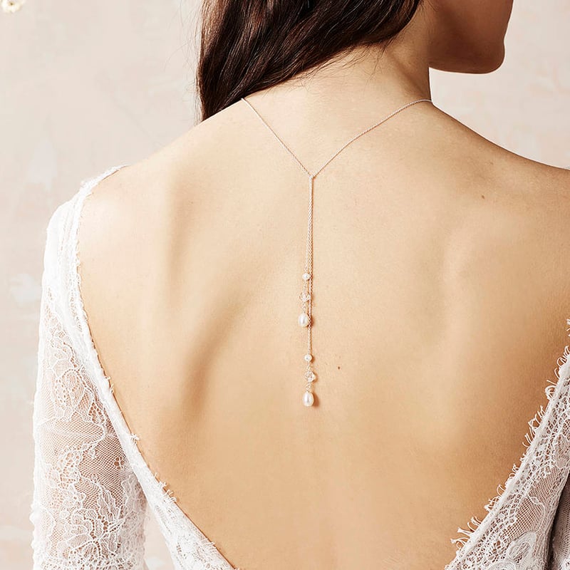 bride in backless dress showing pendant necklace 