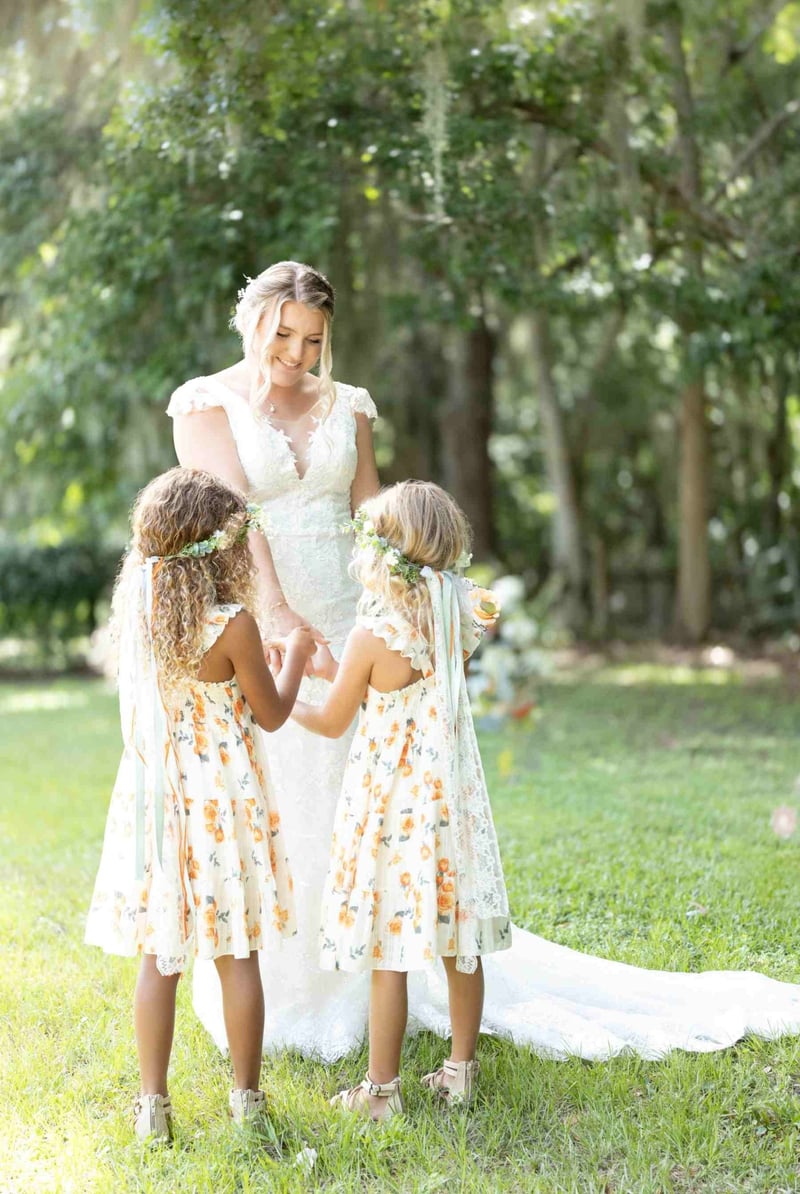 A bride hand in hand with two older girls dressed as bridesmaids