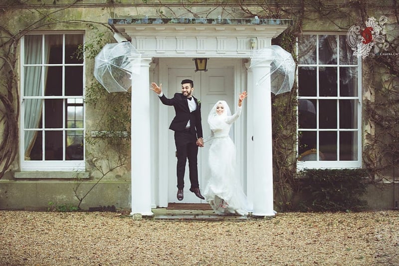 bride and groom of a Muslim wedding outdoors jumping