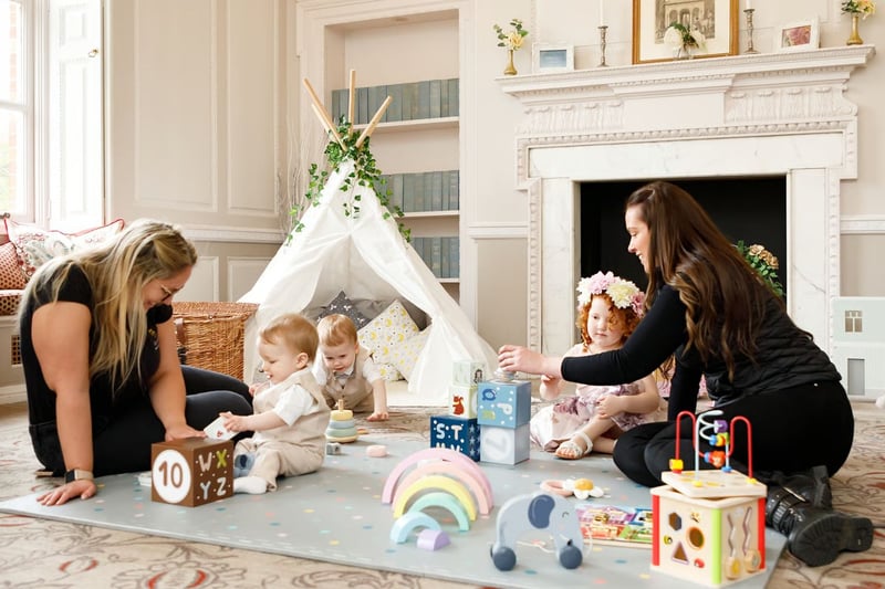 Two childcare professionals playing with little children at a wedding
