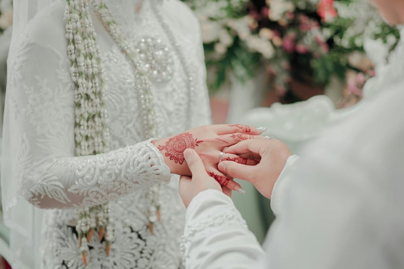 Bride and groom holding hands and exchanging rings at a cultural wedding