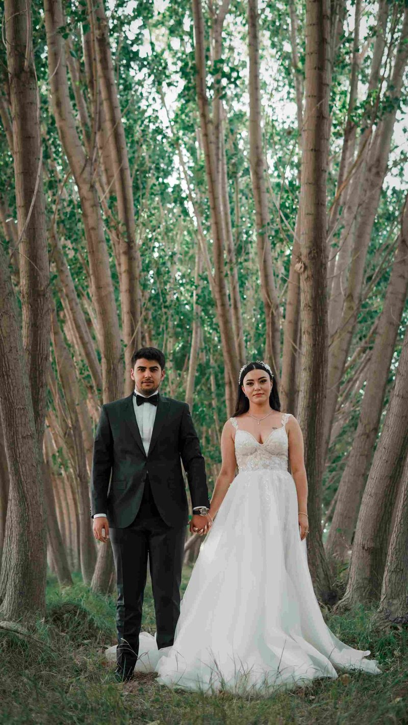 Bride and groom standing hand in hand in a canadian forest