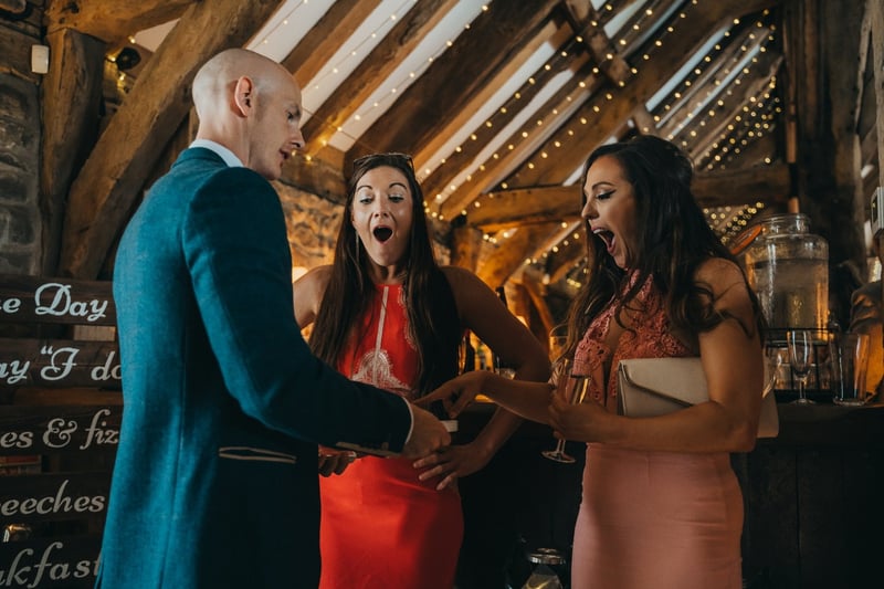 a magician performs a trick to stunned female wedding guests.