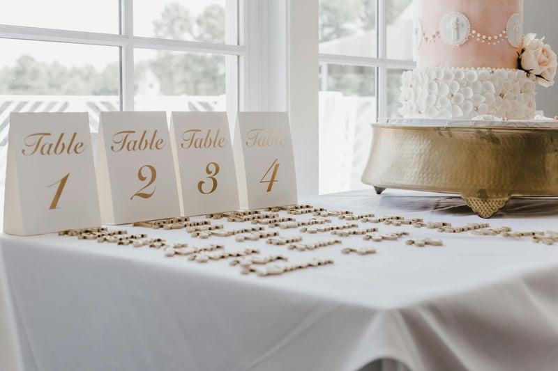 A wedding seating plan laid out next to a wedding cake