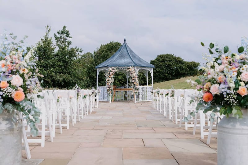 An outdoor wedding ceremony with a gazebo