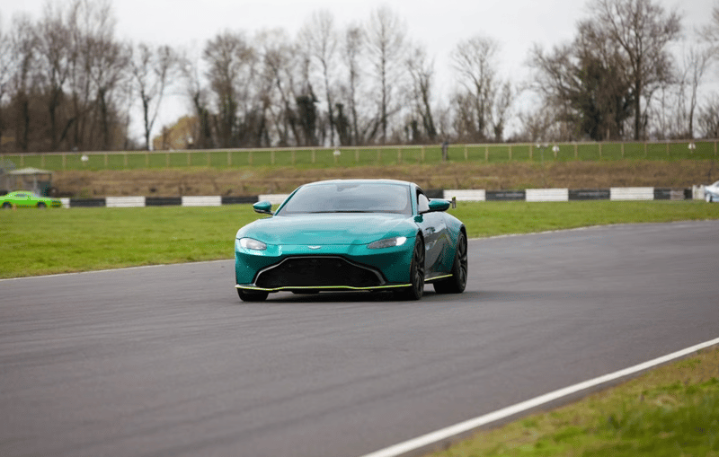 a teal blue supercar racing down a track 
