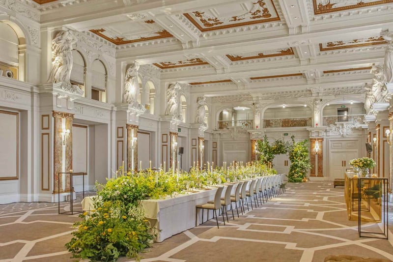 Glamorous wedding reception at London venue Kimpton Fitzroy with a long single banquet table covered in greenery