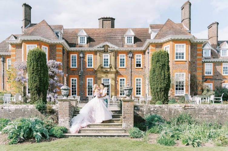 newly wedded couple posing outside the barnet hill wedding venue