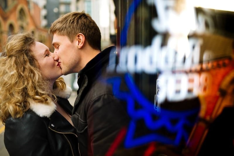 an engaged couple kissing.