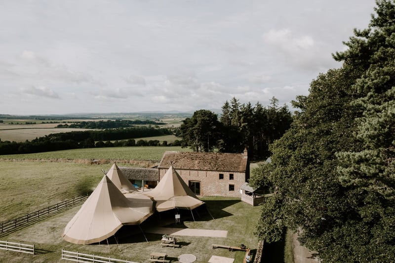 arial view of a country house barn venue with tipi tents.