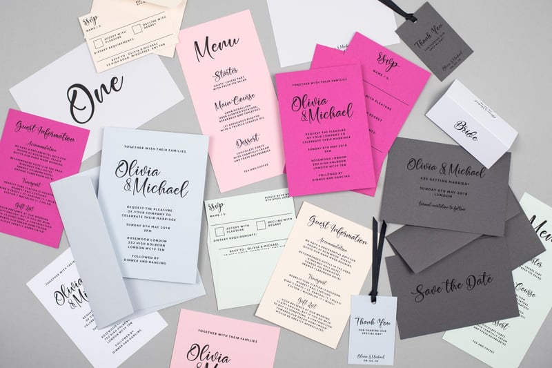 a collection of pink, grey, white and pale blue wedding stationery with a modern font.