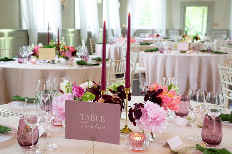 close-up of a wedding table with table number in pink and gold.
