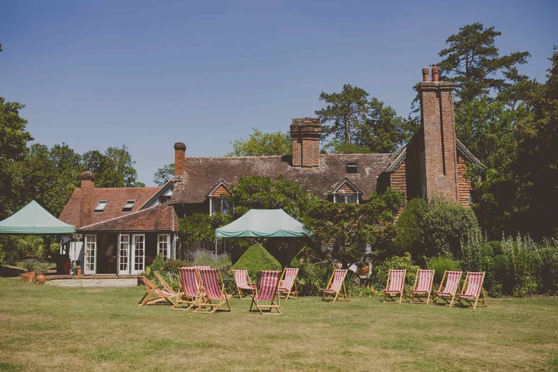 Exterior of ridge farm with striped deckchairs on the lawn