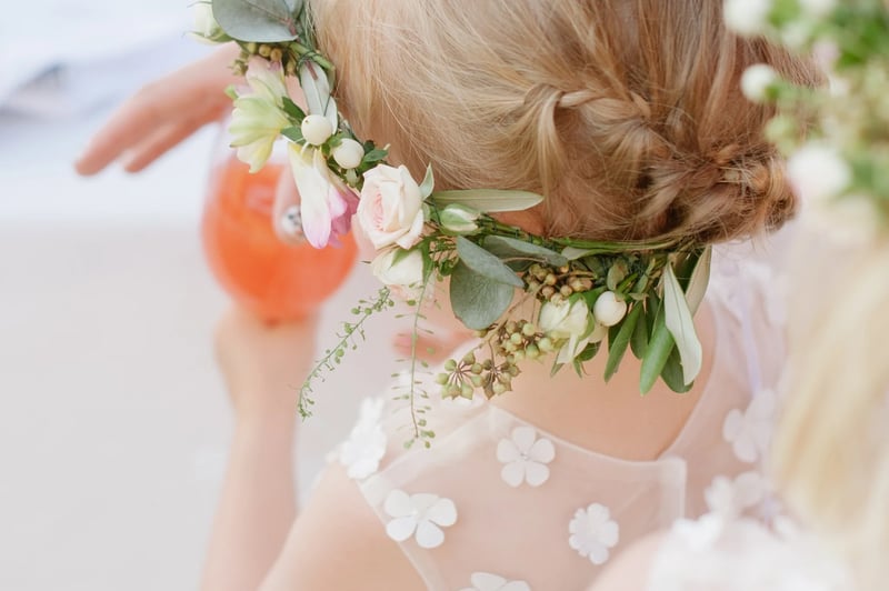 woman sipping an aperol spritz on her wedding day, wearing a flower crown