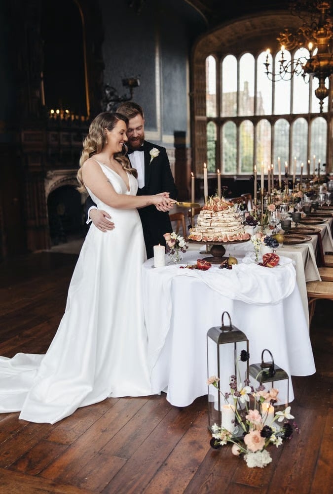 bride and groom cutting into a wedding cake alternative of a meringue stack
