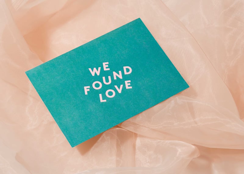 a green wedding invitation that reads 'we found love' on the front.