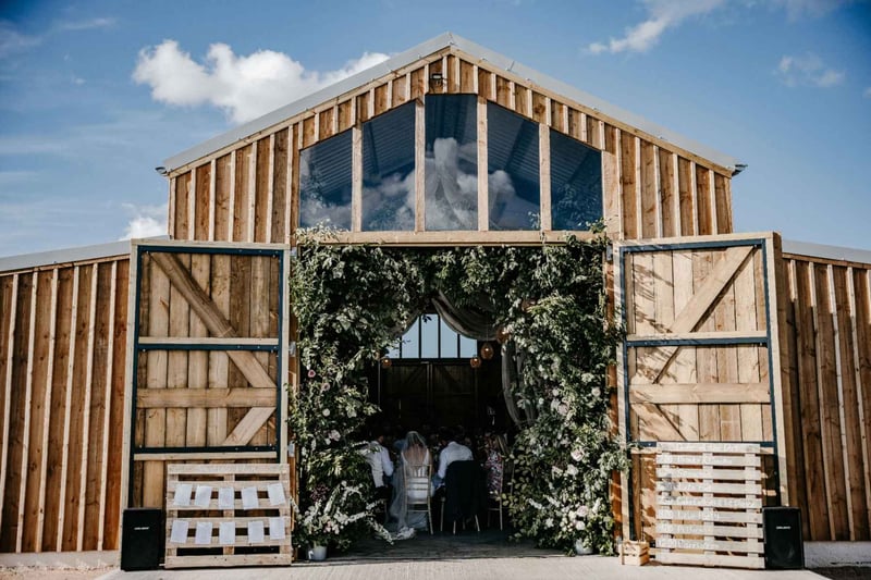 Exterior of a wooden barn wedding venue with the doors wide open
