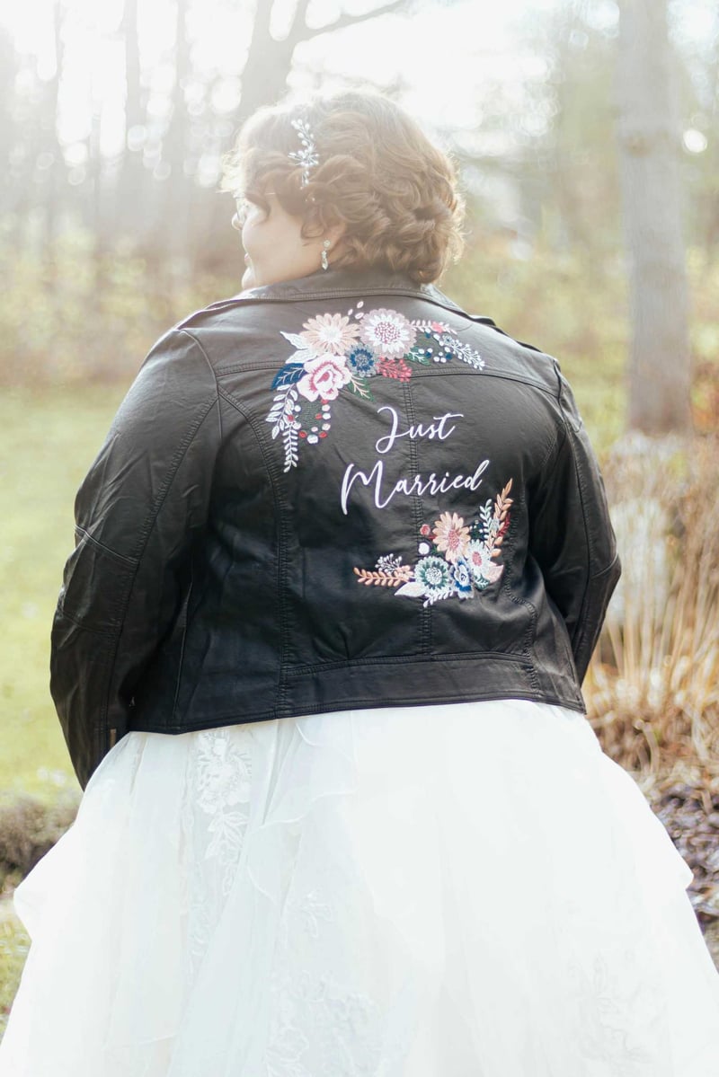 Rear view of an alternative bride wearing a leather jacket that says 'just married'