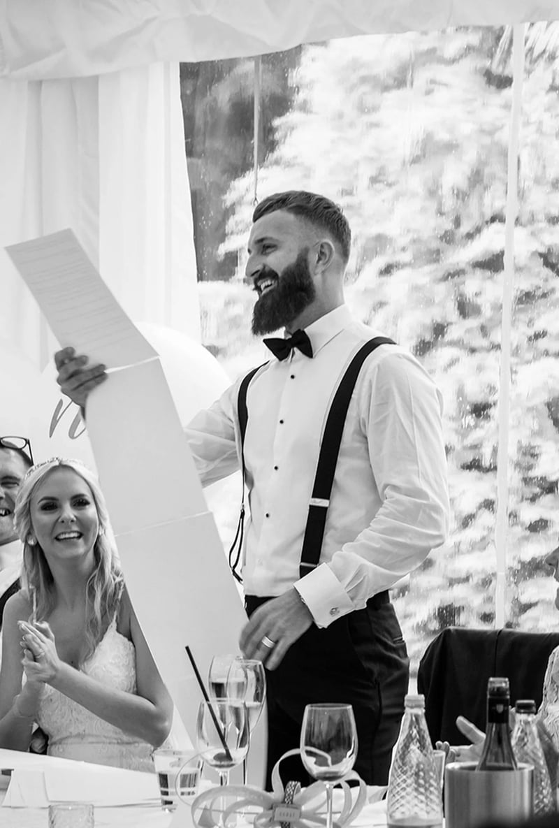 Best man holding a long roll of paper for his best man's speech