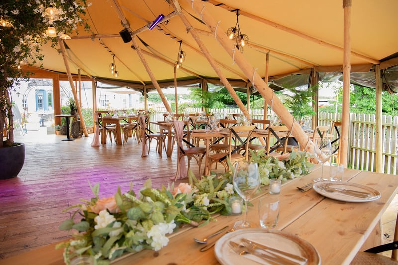 close up of a wedding breakfast table inside an open-sided tipi wedding tent.