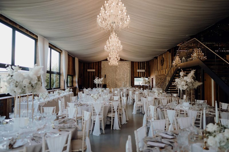 Interior of Bunny Hill wedding venue with a draped ceiling and chandeliers