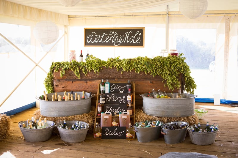 a DIY bar made from galvanised bowls and buckets, chalkboard signs and foliage.