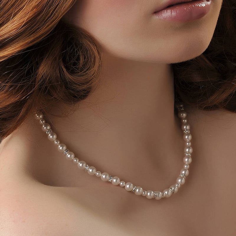 woman with short hair wearing a pearl necklace 