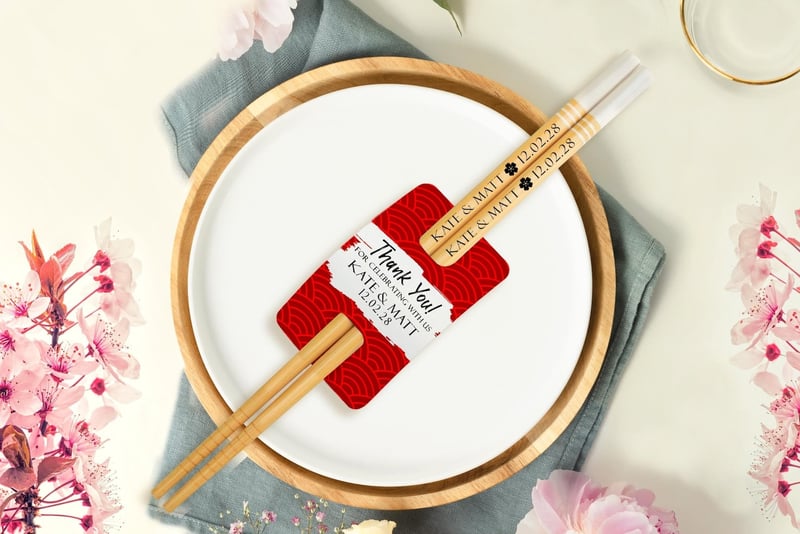 personalised chopstick wedding favours on a plate at a table setting.