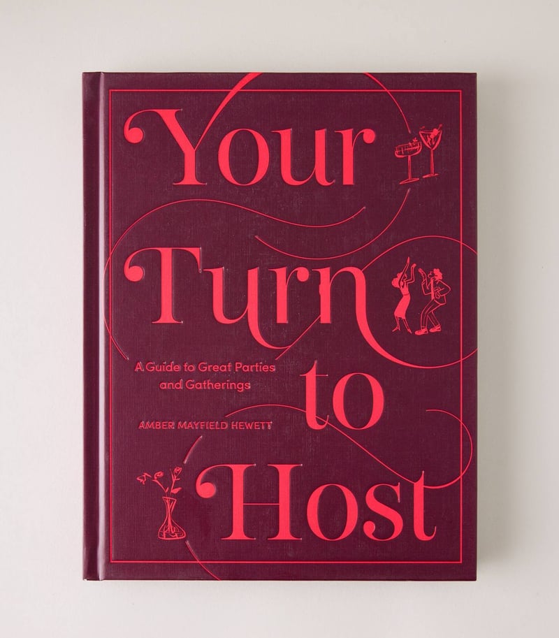 a burgundy and pink book called Your Turn to Host