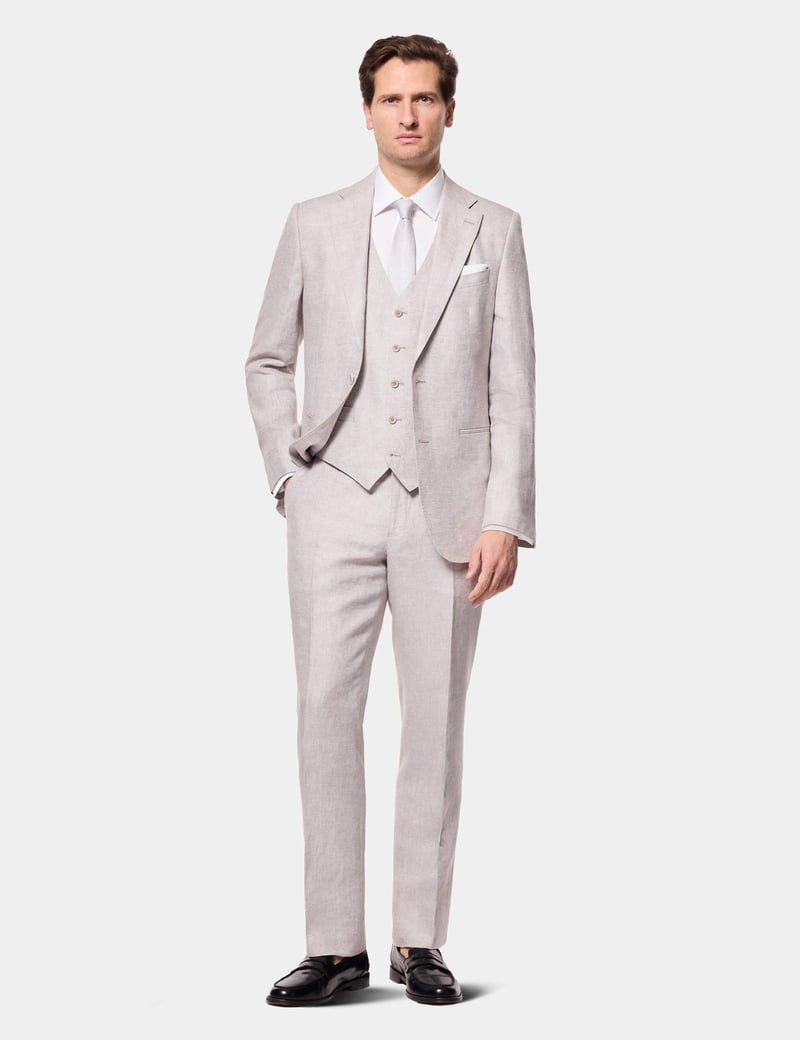 a male model wears a light grey three-piece linen suit.