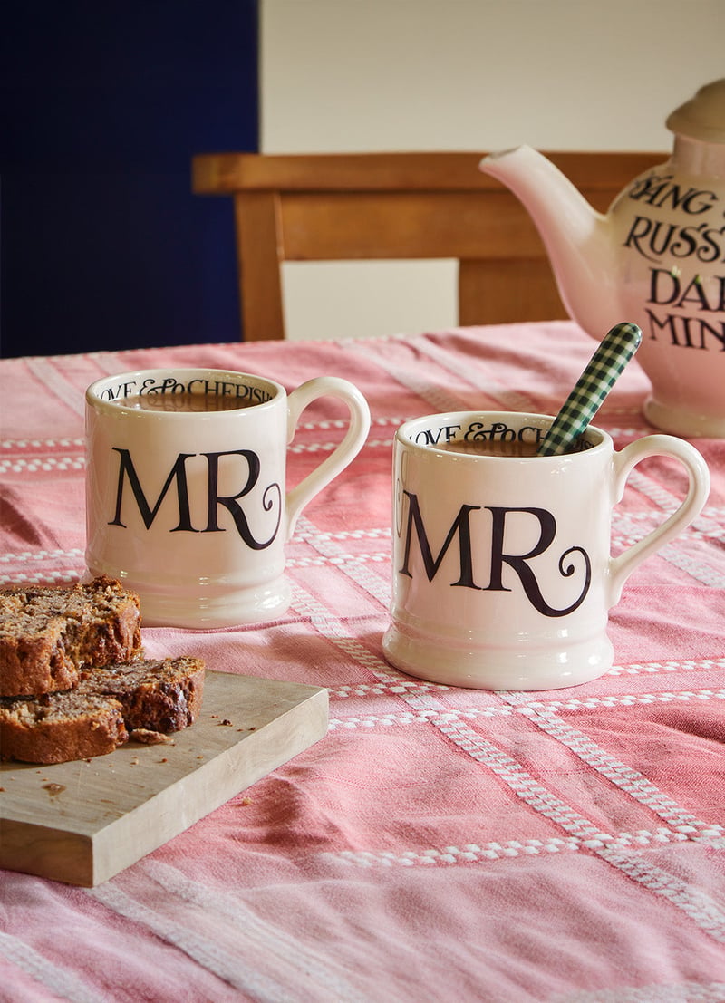 two handpainted mugs on a table that read 'Mr' and 'Mr' in black lettering.