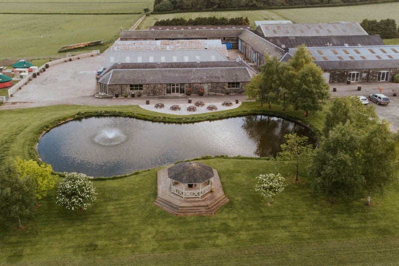 Aerial view of Bachilton Barn wedding venue with pond, fountain and glamping yurts
