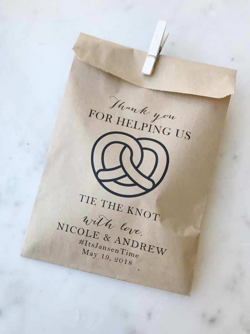 a brown paper pretzel bag with personalised wedding details.