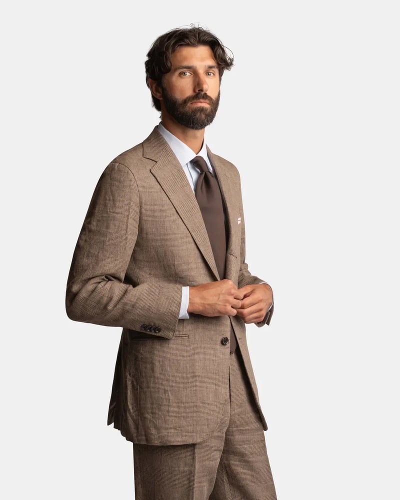 a male model wearing a brown linen suit white white shirt and brown tie.