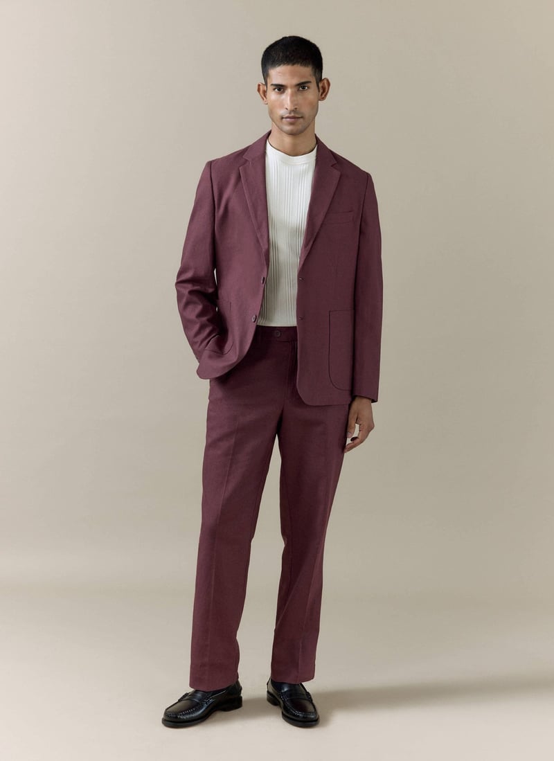 a male model wears a wine-coloured wedding suit with a white t-shirt.