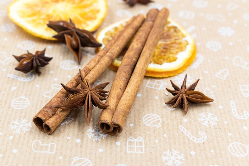 cinnamon sticks and orange slices on a table with star anise.