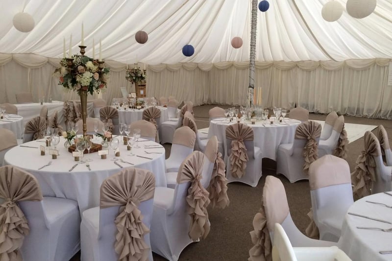 Interior of the grand marquee draped in fabric and decorated with pom poms