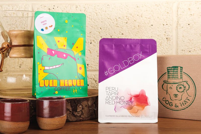 two bags of colourful coffee beans and espresso cups