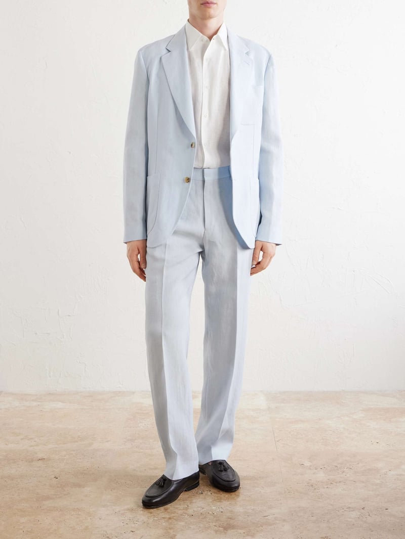 a male model wears a light blue linen wedding suit with white shirt.