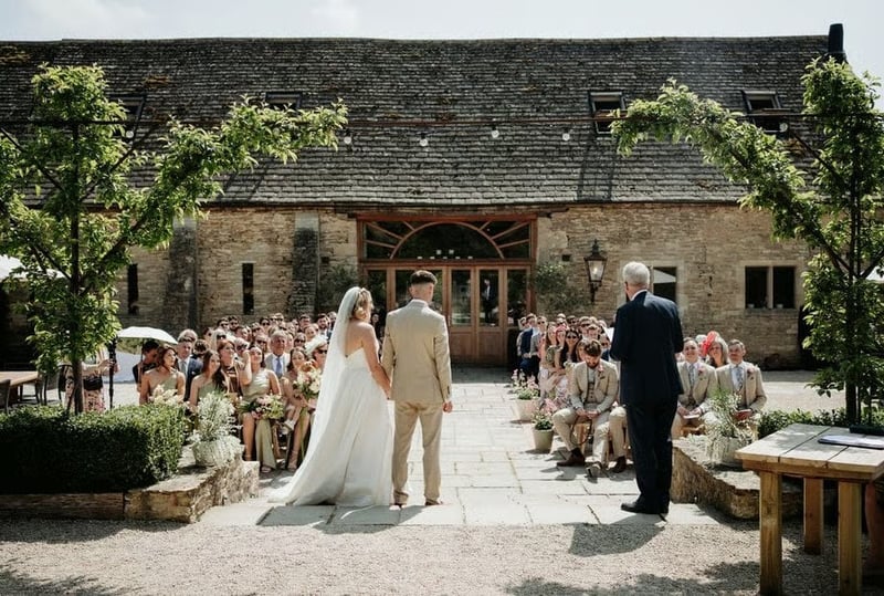 Bride and groom at an outdoor wedding ceremony at Oxleaze Barn