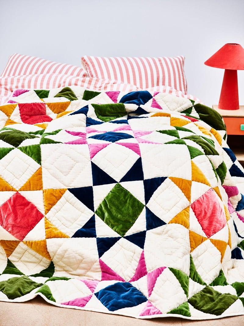 a colourful patchwork throw on a bed.