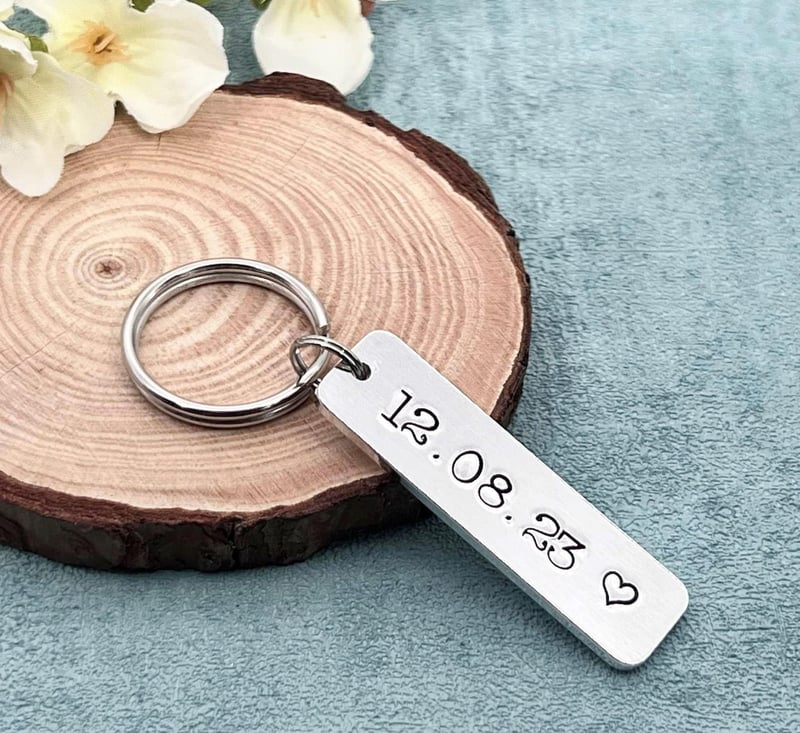 a silver keyring engraved with a wedding date.