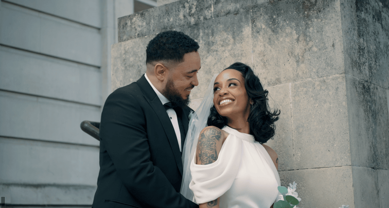a newlywed bride and groom smile at each other.