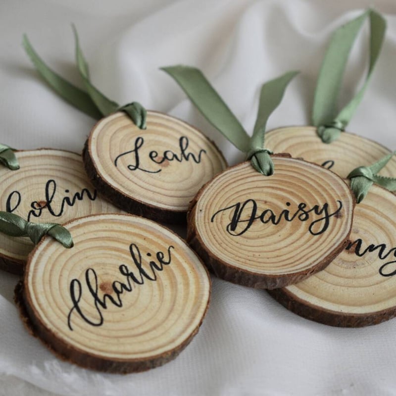 personalised log slice decorations tied with green ribbons