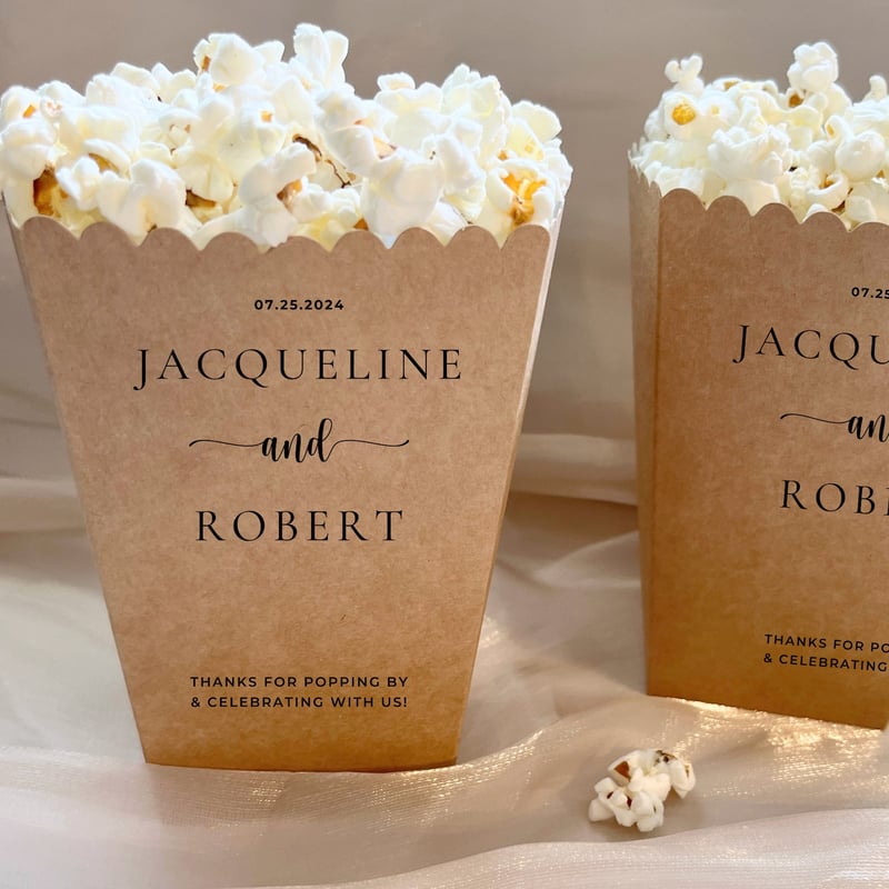 brown paper boxes filled with popcorn personalised with wedding couple names and date.
