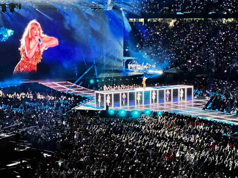 Taylor Swift performing at an arena in front of thousands of fans