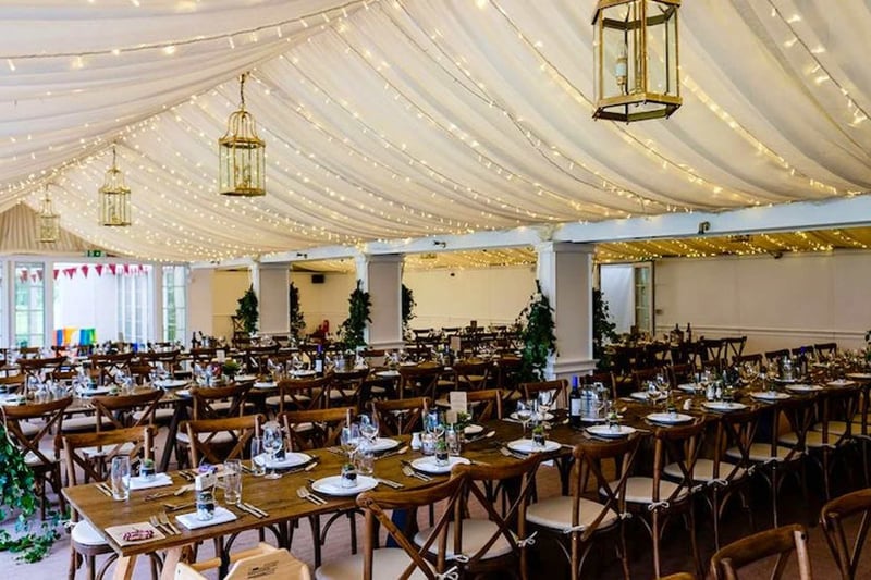Interior of the riverside marquee, decorated with fairylights and long banqueting tables